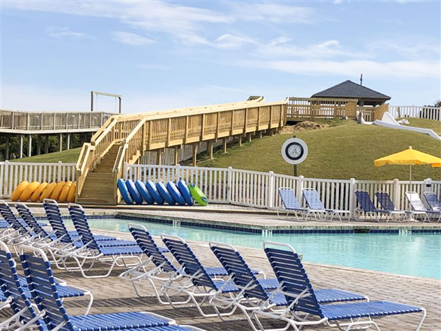 A spacious outdoor swimming pool with a water slide at VRI's A Place at the Beach, Atlantic Beach, NC.